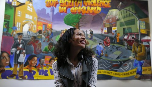 Holly Joshi in front of mural that says STOP YOUTH VIOLENCE IN OAKLAND