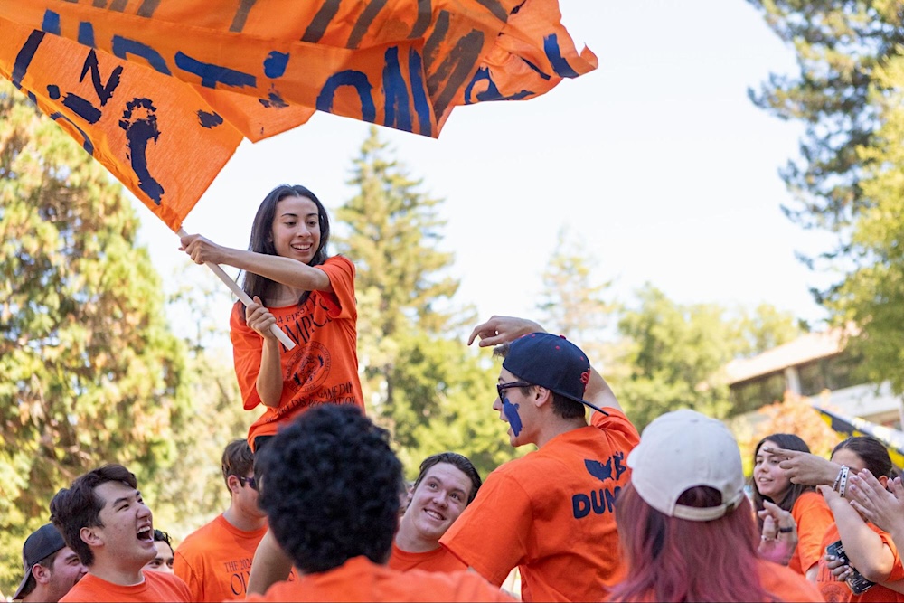 Student waving orange flag at first year olympics 2024