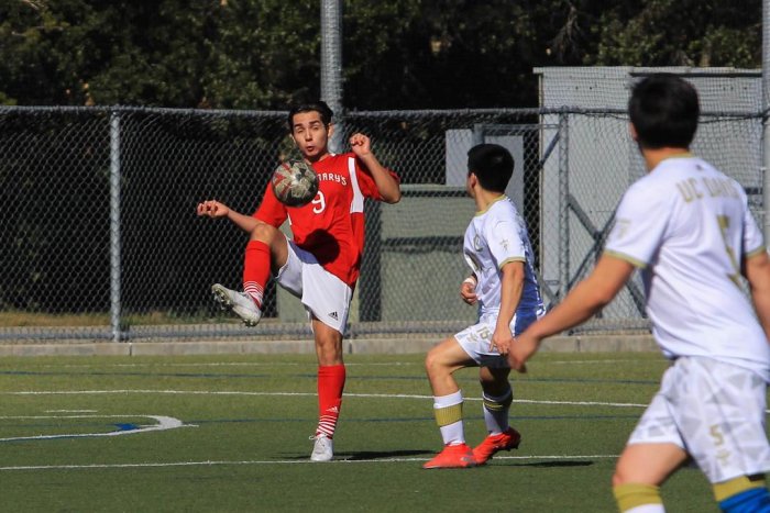 A men's soccer player dribbling the ball