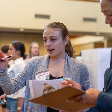 Student discussing their conference presentation