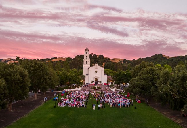 A Saint Mary's College campus event with tables and lights on the chapel lawn