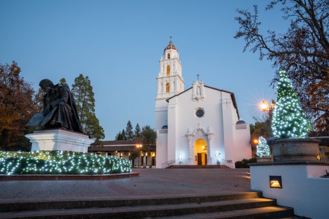 Saint Mary's College chapel with holiday lights on the trees and bushes 