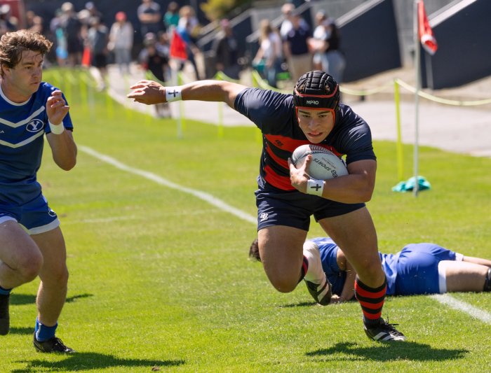 Men's rugby player Dominic Besag runs past BYU defenders, April 2024