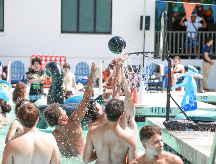 Hoop it up: First years gather in the shallow end to play pick-up basketball in the pool during the Weekend of Welcome Pool Party on August 24, 2024. / Photo by Ashleen Rai ’26